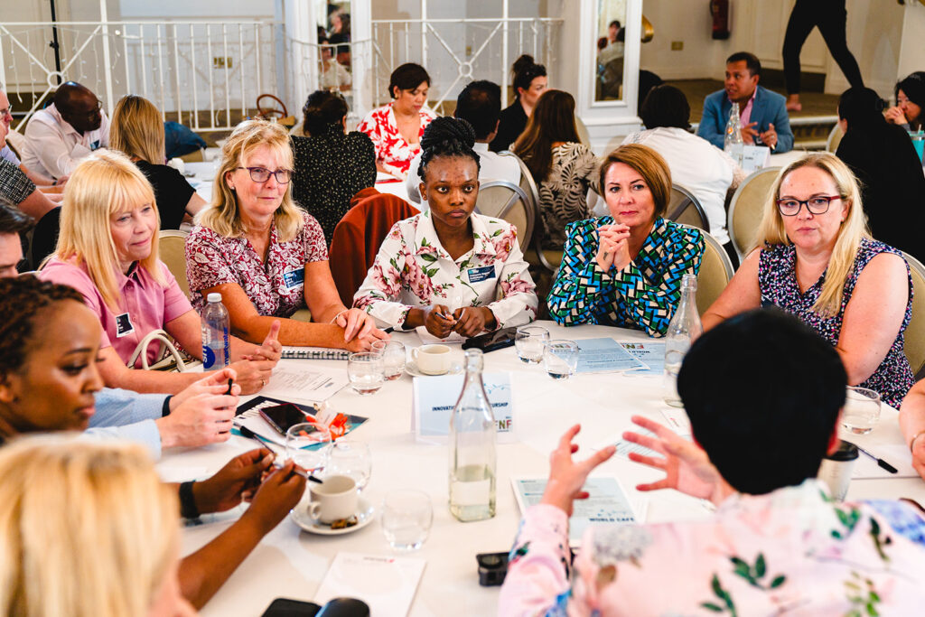 A group of people sitting round a table listening to people talking.