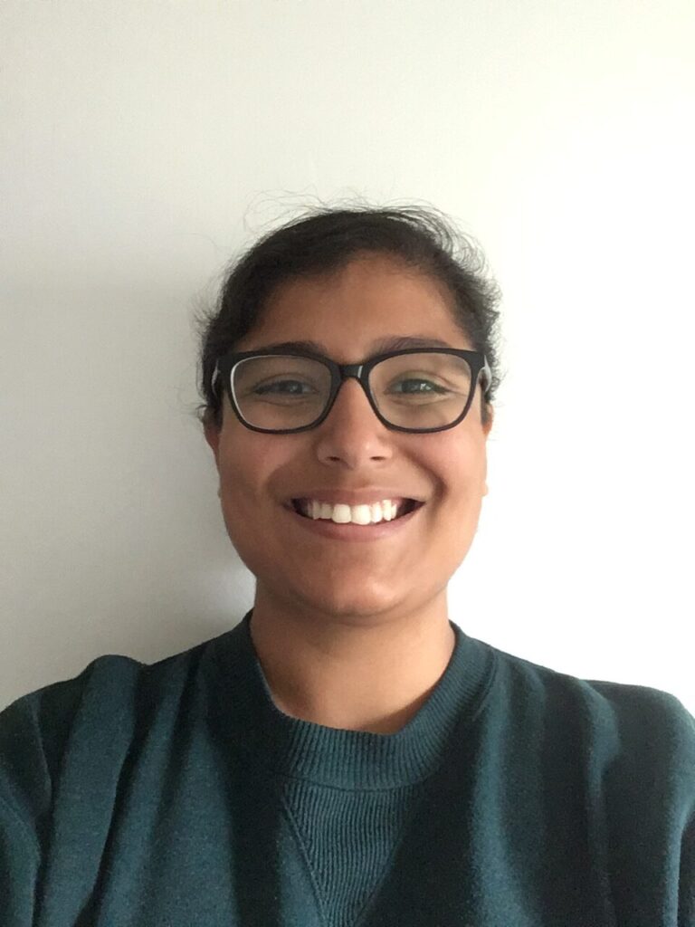 smiling woman with glasses and a green top