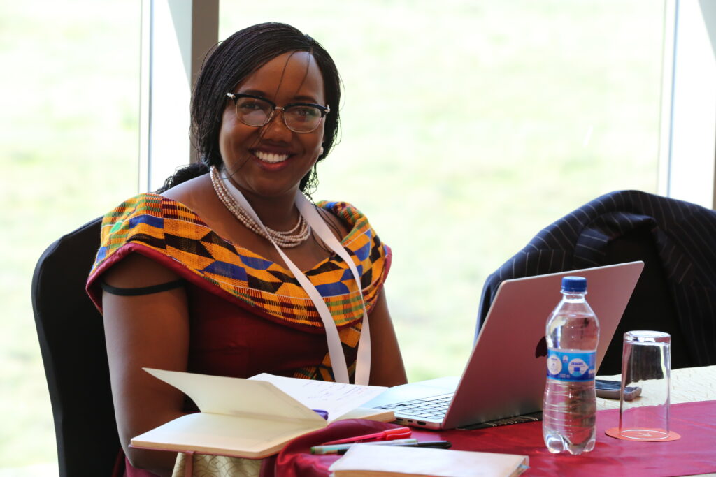 Woman sat behind a table, smiling.