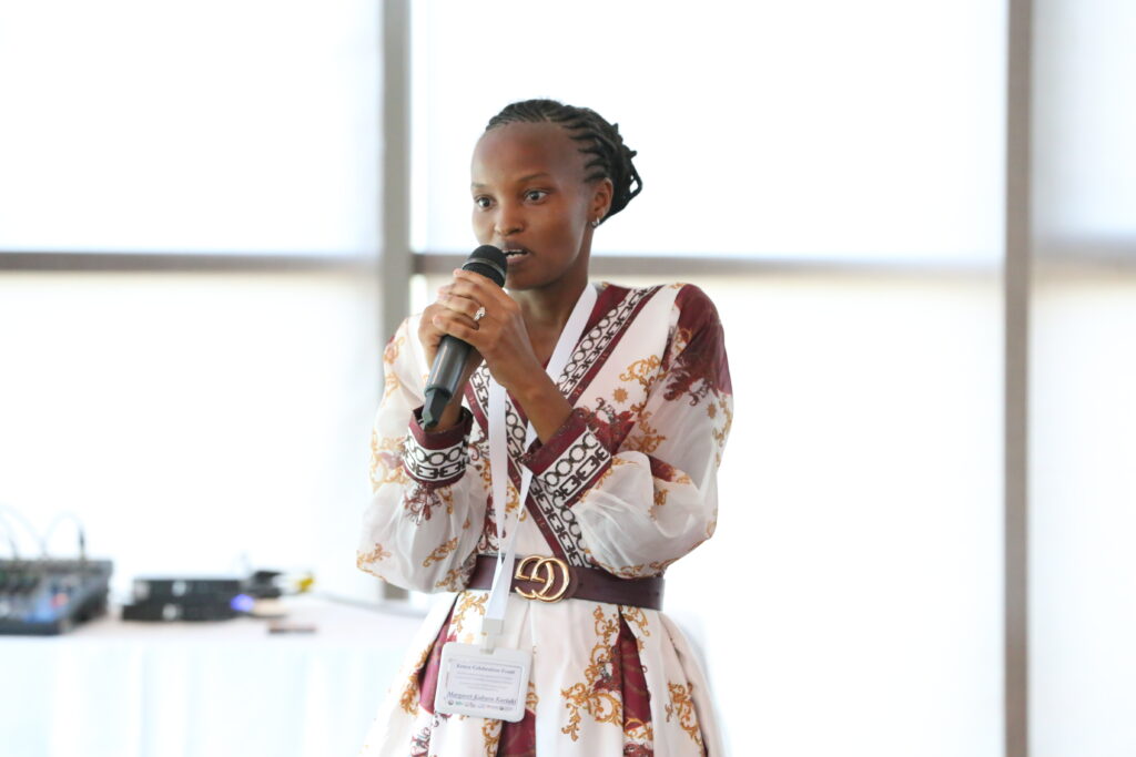 A woman standing in a room speaking into a microphone