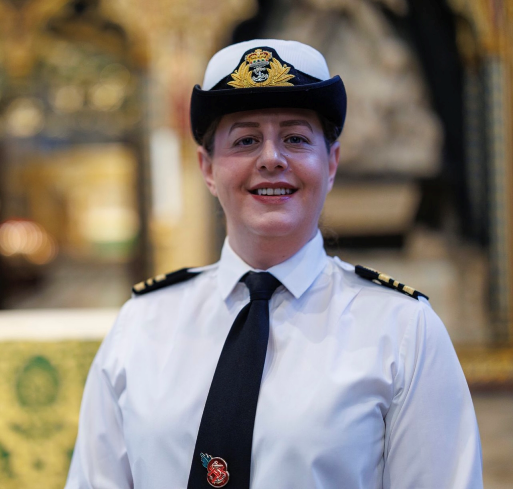 Woman in military uniform, smiling.
