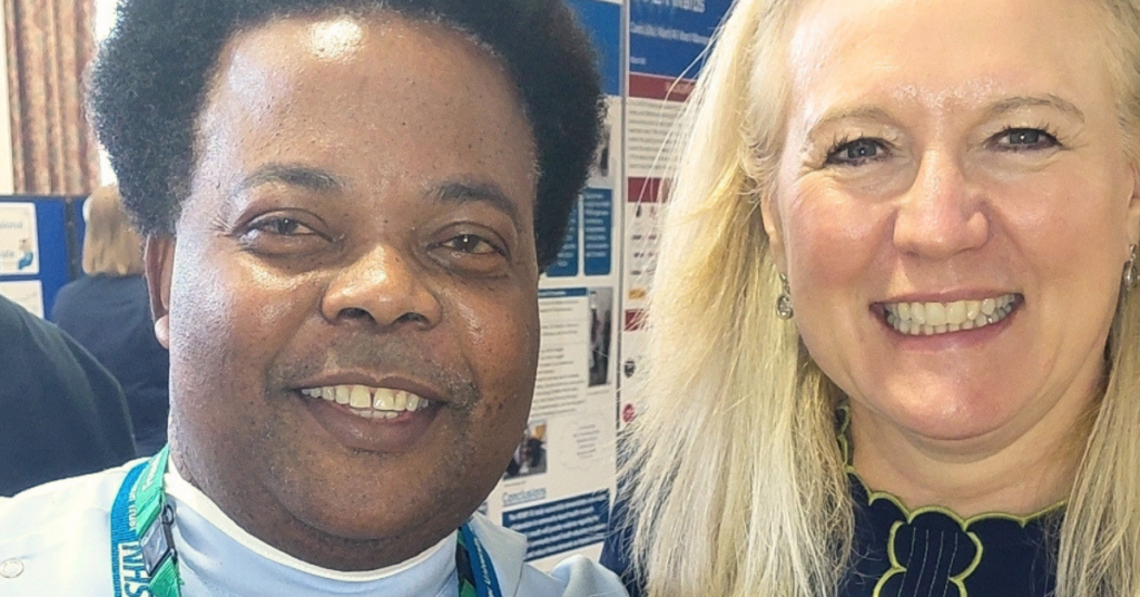 A cropped head and shoulders image of a man and woman smiling. The man has dark hair and the woman has blonde hair.